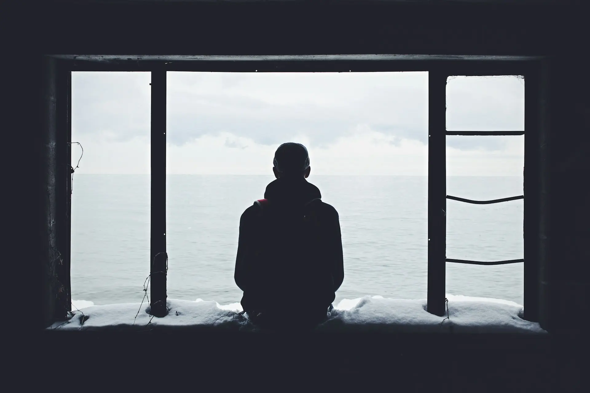 Un homme seul vu de dos regardant la mer