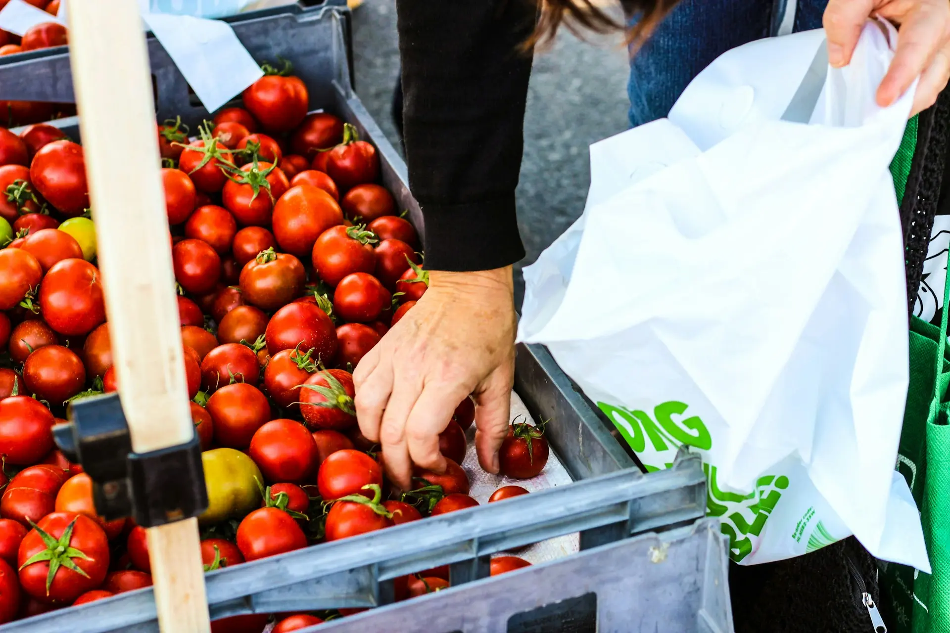 Une personne choisissant des tomates sur un marché